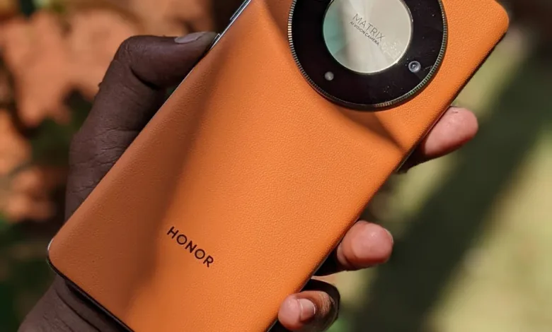 close up of hand holding an orange smartphone